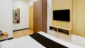 A modern bedroom with a bed, wardrobe, TV, and a small desk area. - Deluxe Super Collection O Kollur Prime (Hyderabad)