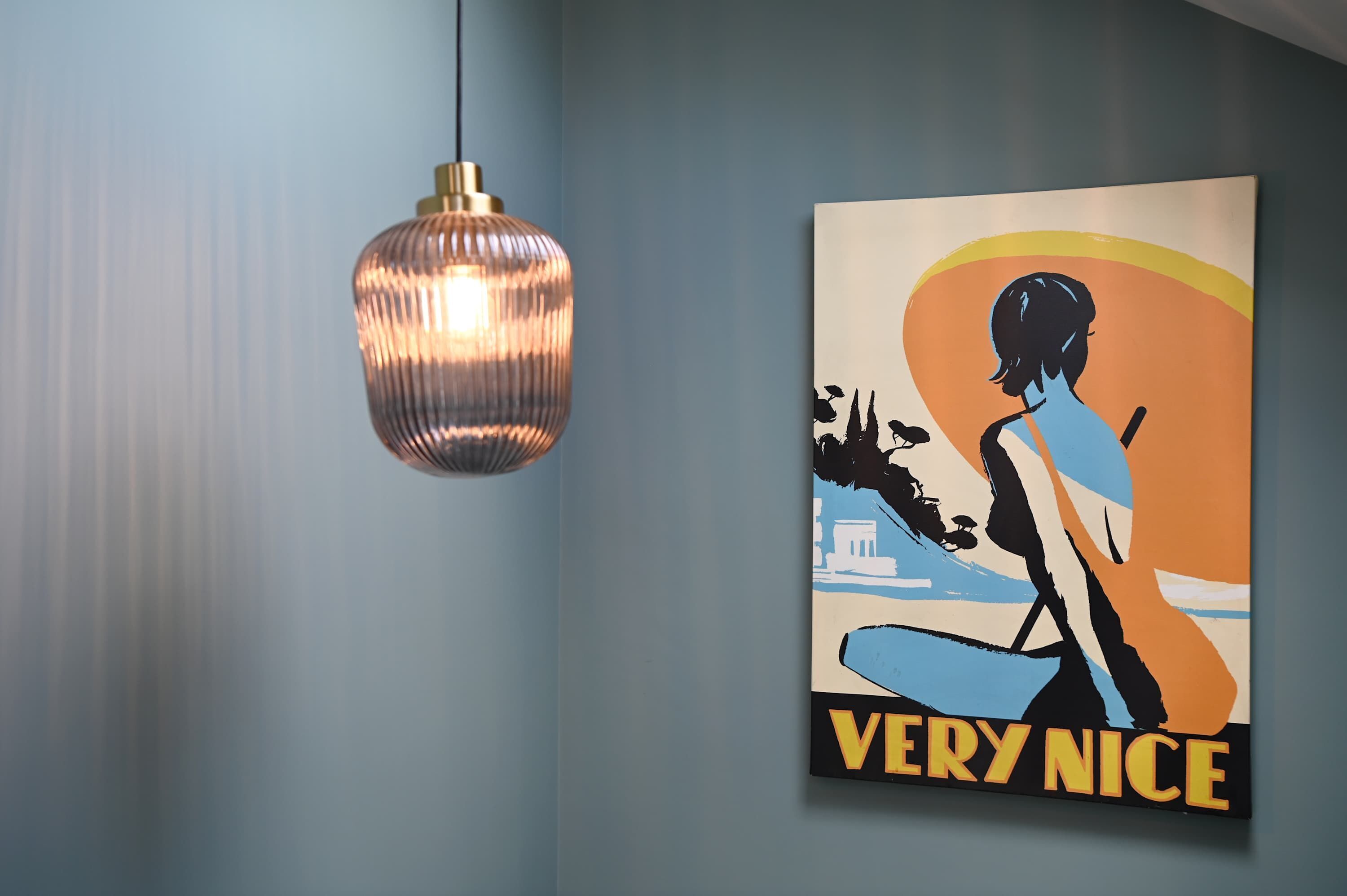 A wall with a poster and a hanging light fixture.