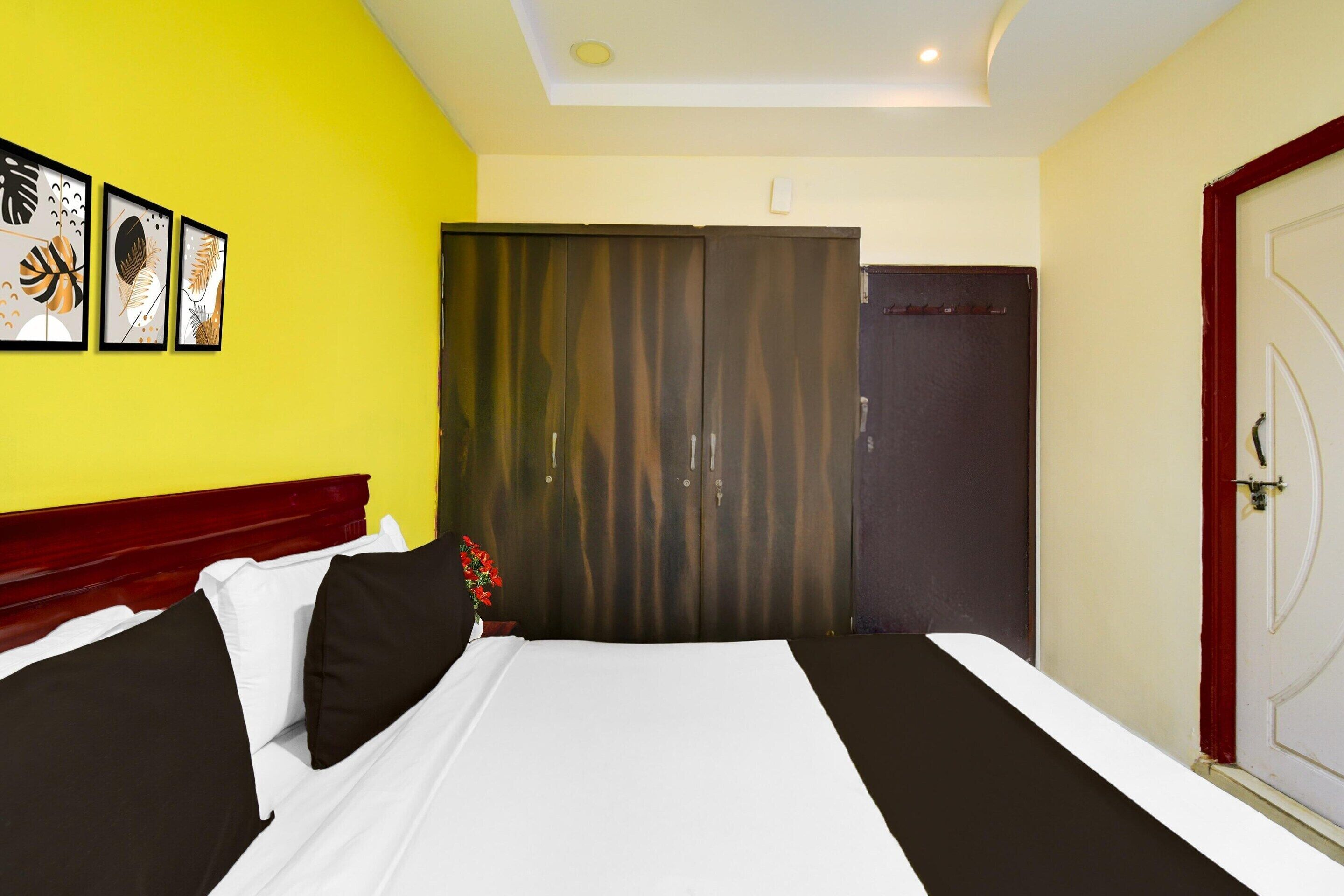 Une chambre d’hôtel avec un lit, une armoire, une porte et des œuvres d’art murales.
