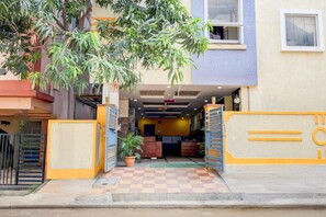 A hotel entrance with a checkered floor, a potted plant, and a gate. - Deluxesri Vinayaka Luxury Rooms (Hyderabad)
