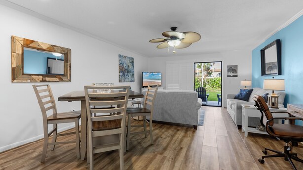 Un salon moderne comprenant un coin repas, un ventilateur de plafond et une vue sur l’extérieur.