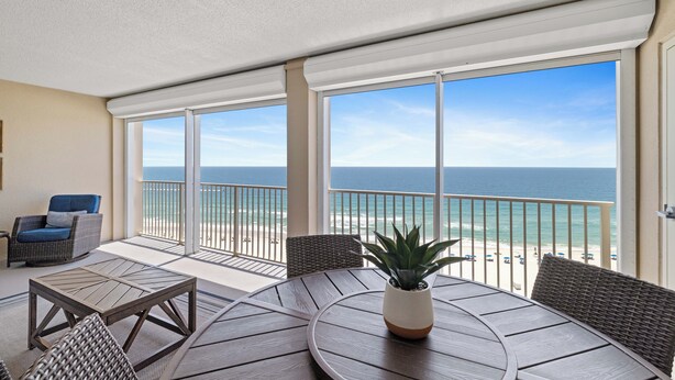 Ein Balkon mit Blick auf das Meer, Korbmöbel und einem Blumentopf.