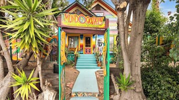 A colorful art house with a vibrant entrance and a staircase leading to the door.