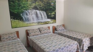 Un dormitorio con dos camas individuales, una cama grande y un televisor de pared que muestra una cascada.