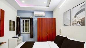 A bedroom with a bed, a wardrobe, a desk, and an air conditioning unit. - Deluxe sri Balaji Luxary Rooms (Hyderabad)