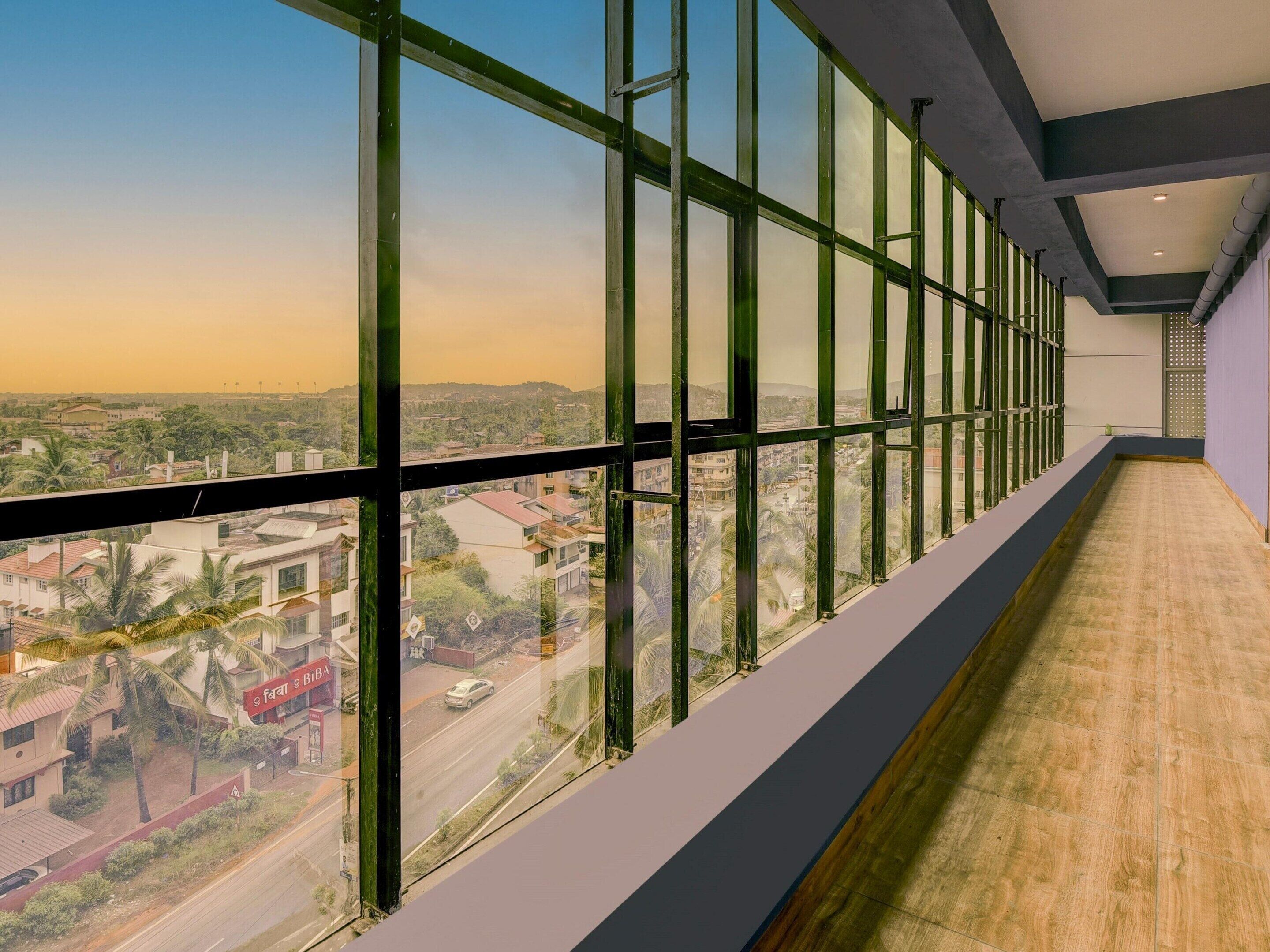 A long corridor with large windows offering a view of a cityscape.