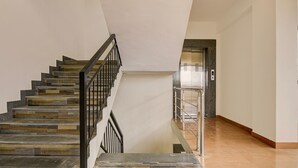 Una escalera de diseño moderno, con barandilla de metal y piso alfombrado.