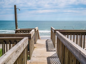 A wooden boardwalk leading to a beach with a clear view of the ocean. - Observation Cove #217 (Topsail Beach)