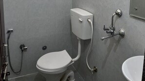 A bathroom with a toilet, bidet, shower, and sink. - The golden nest (Hyderabad)