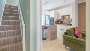 Una cocina moderna con armarios blancos, salpicadero de azulejos y electrodomésticos de acero inoxidable.