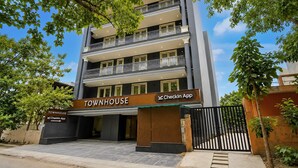 Een meerlaags gebouw met een bordje voor 'TOWNHOUSE' en een bord 'CheckIn App'.