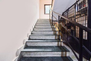 A staircase with a metal railing, leading to a higher floor. - Deluxe Secunderabad Near Railway Station (Hyderabad)