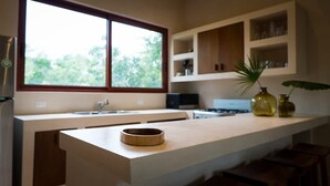 A kitchen with a large window, a built-in oven, and a wooden countertop. - Exclusive 3BR Sky Penthouse w/Private Rooftop Pool (Tulum)