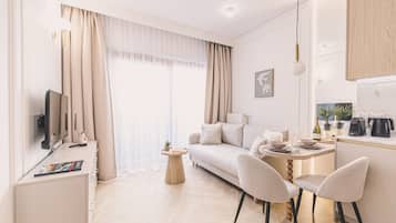 Una sala de estar moderna con un sofá, dos sillones, una mesita y un televisor.