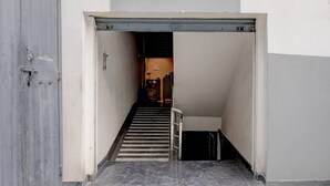 A stairway leading to a room with a bed, a nightstand, and a wall-mounted shelf. - Deluxesriman Stay INN (Hyderabad)