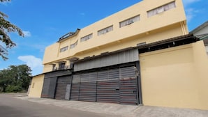 A two-story building with a closed garage door, a flat roof, and a clear sky. - Chic Deluxe Twin Comfort Stay w/ Free Wifi (Semarang)