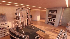A gym with weightlifting equipment, kettlebells, and a bench. - Villa Verdejo Luxury 2-Bedroom, 2-Bathroom Apartment with Pool & Spa (Olivella)