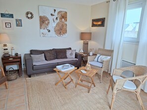 A living room with a sofa, two armchairs, a coffee table, a lamp, and a wall with artwork. - Plouneour-trez Holiday Home With Seaview (Plounéour-Brignogan-Plages)
