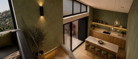 Une cuisine moderne avec un coin bar, un escalier et une vue sur l’extérieur.