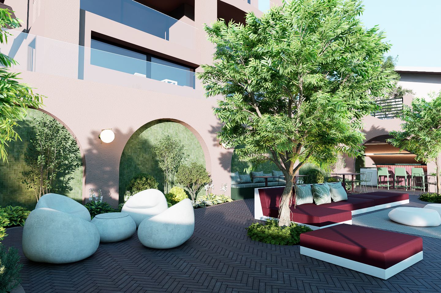 An outdoor seating area with modern furniture and a tree, surrounded by a building with large windows and an arched entrance.