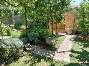 Ein Garten mit einem Kiesweg, unterschiedlicher Bepflanzung und einem Holzzaun.