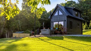 A wooden cabin with a sloped roof, a covered porch, and a large window. - Hot Tub Outdoor Movies Firepit Mtn Views (Mills River)