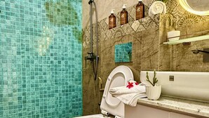 A bathroom with a toilet, shower, and sink.