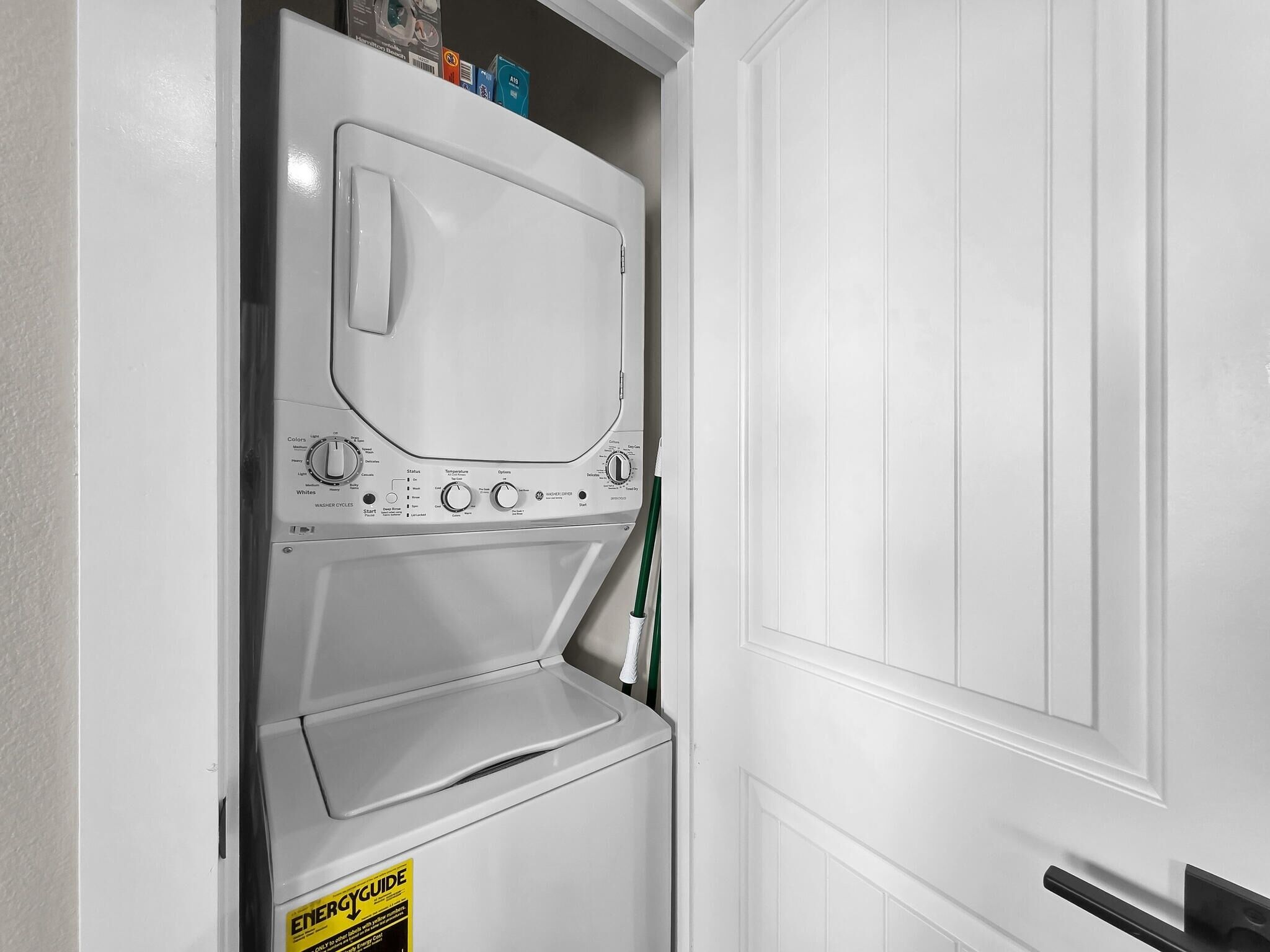 A white washing machine in a utility room with a door to the right.