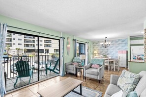 A living room with a balcony, a dining area, and a kitchen. - Myrtle Beach Resort B0116 (Myrtle Beach)