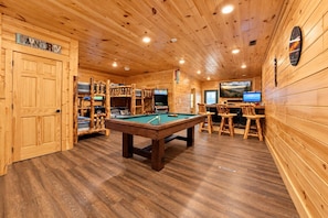 A wooden interior with a pool table, bar area, and a television. - Gatlinburg Views Lodge 5 Bedroom Cabin (Gatlinburg)