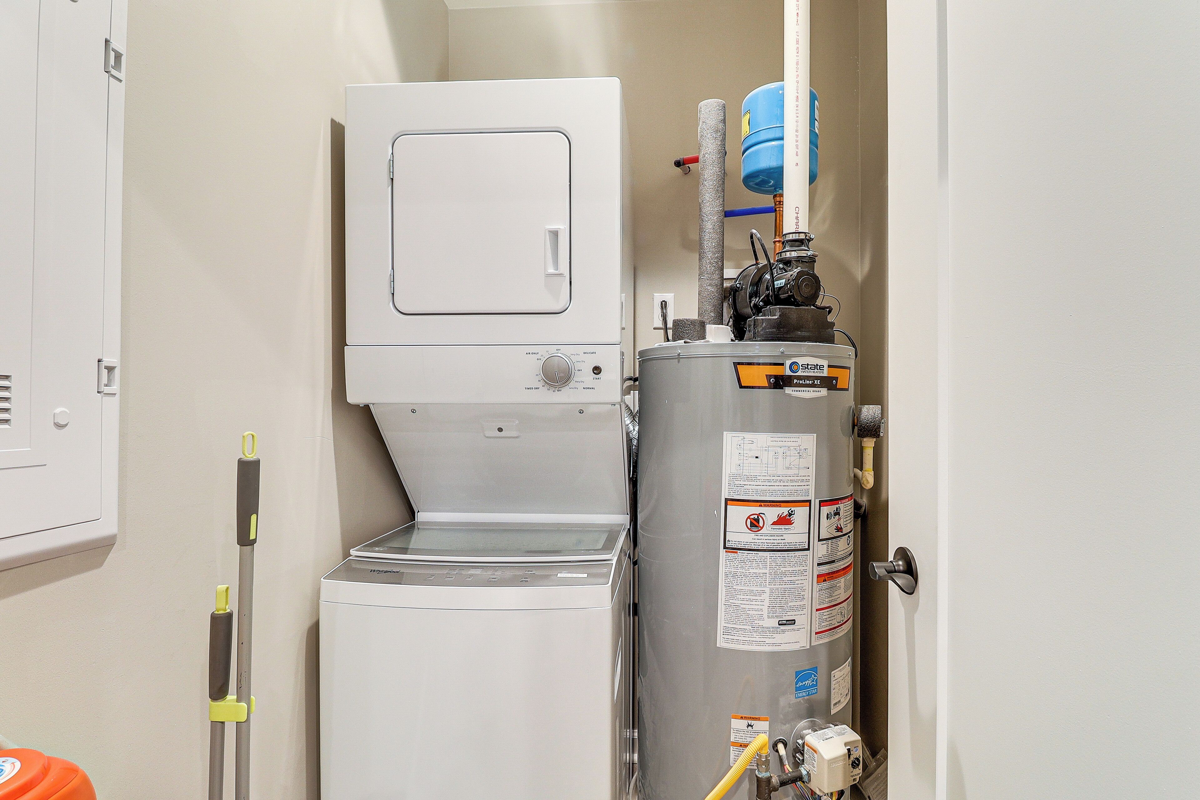 Een kleine kamer met een witte verwarming, een boiler en een bedieningspaneel aan de muur.