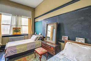 A room with two beds, a dresser, a mirror, and a radiator. - Warrior Trail Access! Converted Schoolhouse Suite (Gary)