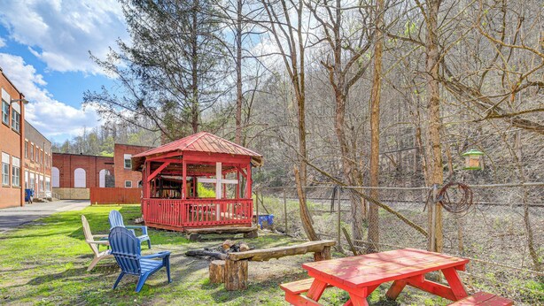 A picnic area with a red table and benches, a small red shelter, and a bird feeder. - Warrior Trail Access! Converted Schoolhouse Suite (Gary)