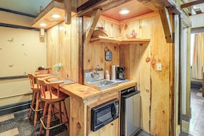 A wooden kitchen with a sink, stove, and bar stools. - Warrior Trail Access! Converted Schoolhouse Suite (Gary)