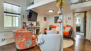 Een woonkamer met een bank, fauteuil en een televisie.