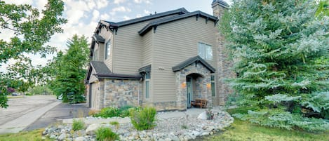 A two-story house with a stone facade and a stone chimney.