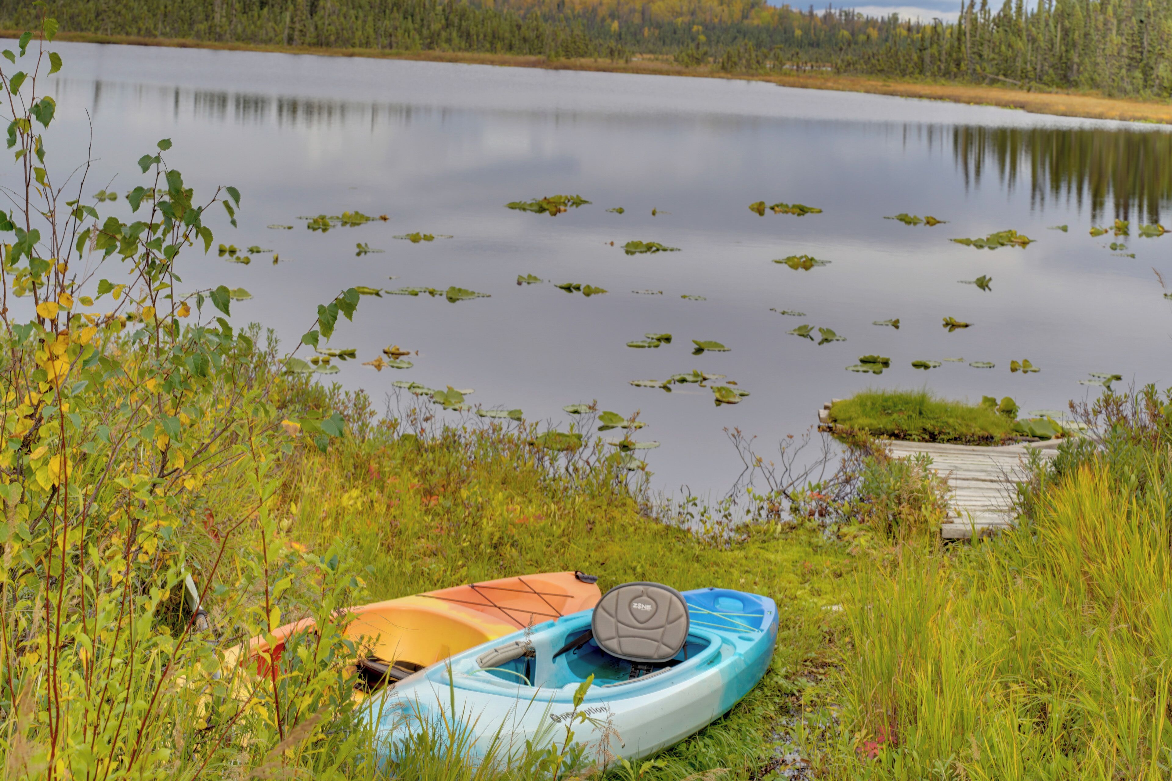 Un lago tranquillo con kayak e un molo.