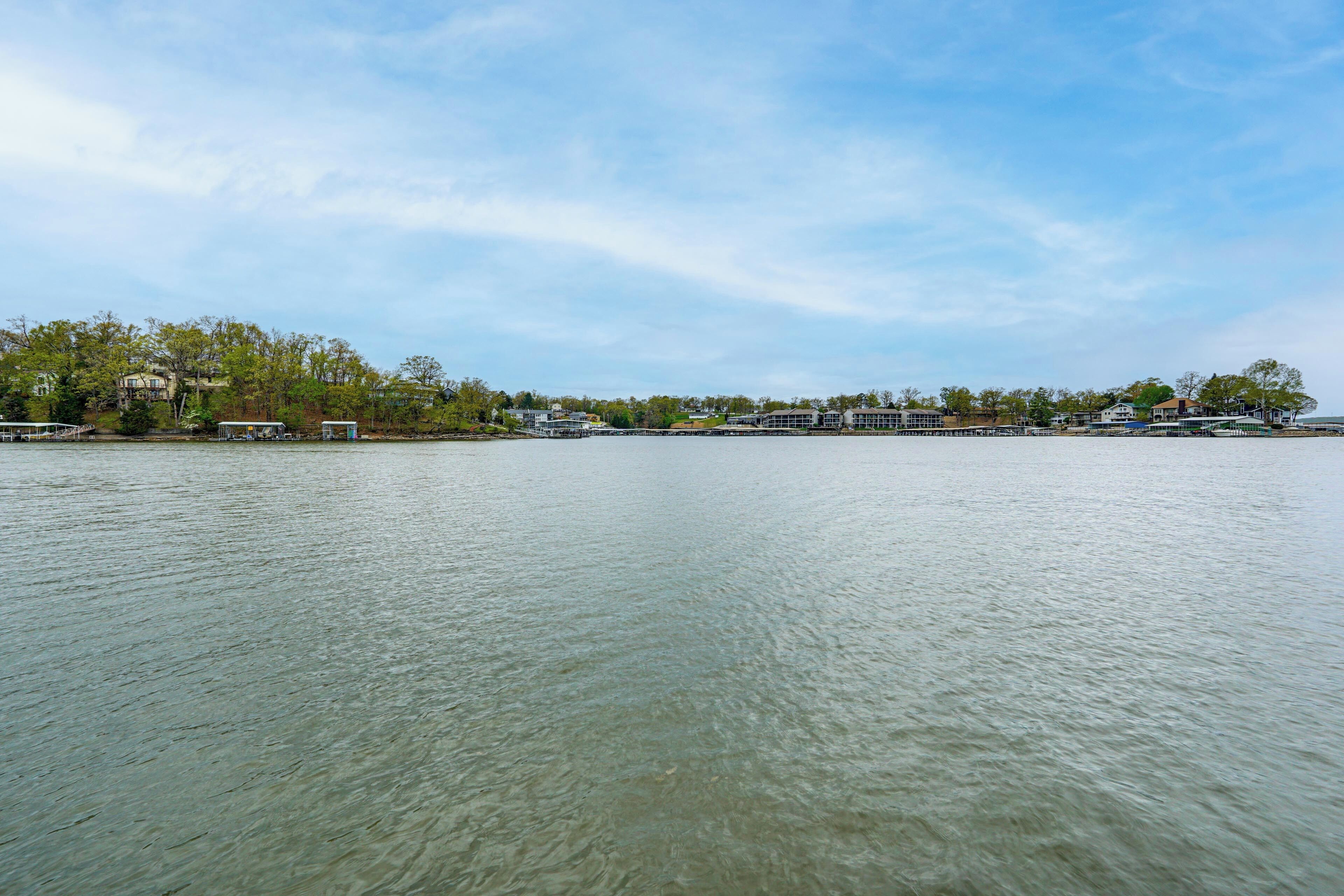 A waterfront property with a dock, a pier, and a row of buildings along the shore.