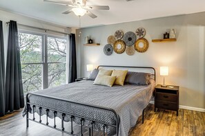Ein Schlafzimmer mit Bett, Nachttischen, Deckenventilator und Wanddekoration.