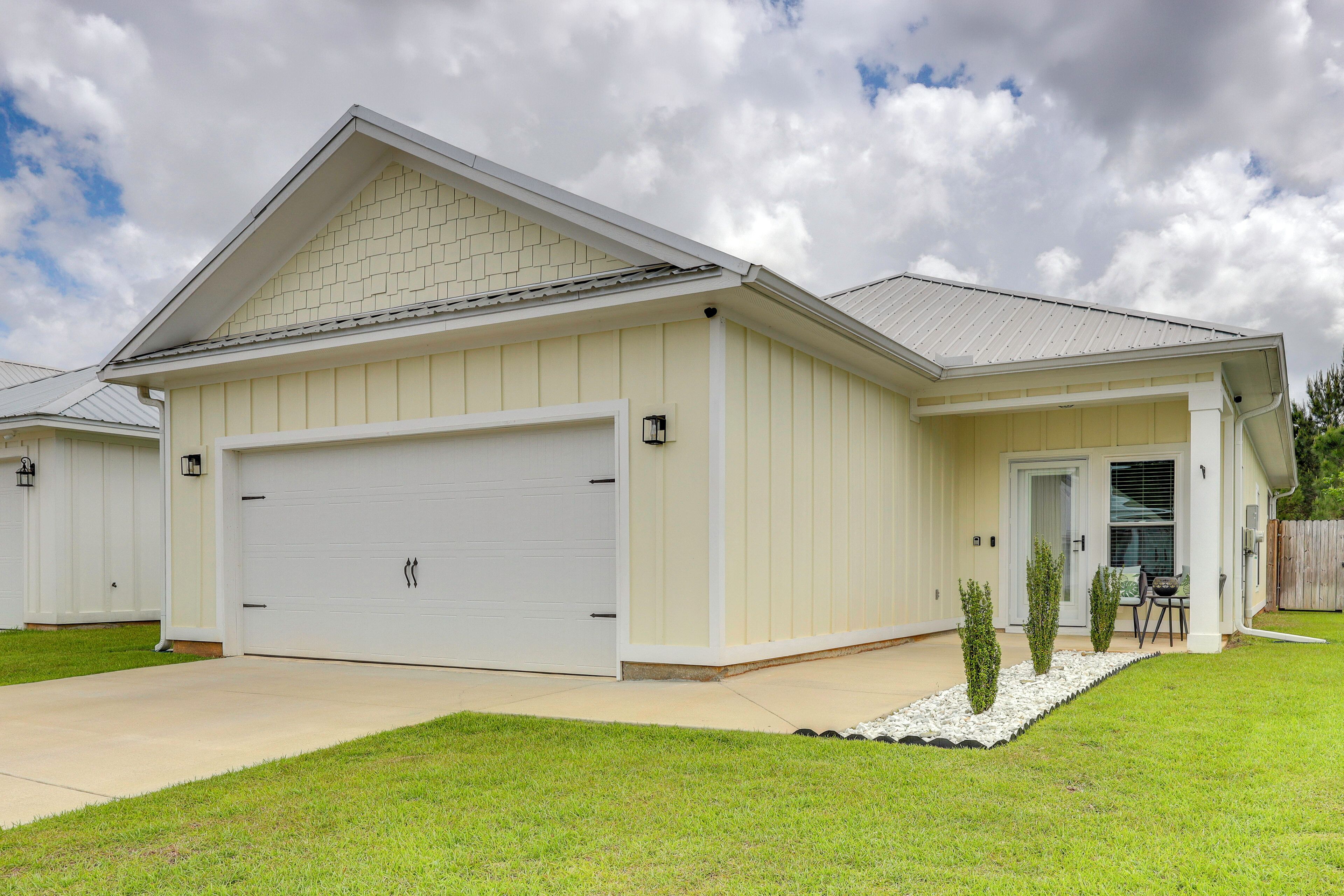 A single-story house with a garage, a front door, and a small patio area.