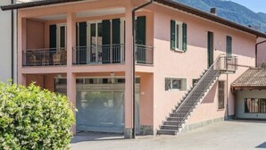 A two-story building with a balcony, a staircase, and a mountain in the background. - Terrazza Segreta around Como Lake by Interhome (Carlazzo)
