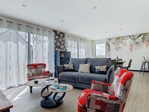 Ein Wohnzimmer mit grauem Sofa, rotem Sessel und Couchtisch.