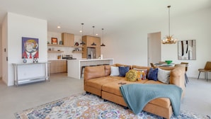 A modern living room with a sofa, a coffee table, and a patterned rug. - Hot Tub & Views! Contemporary Yucca Valley Retreat (Yucca Valley)