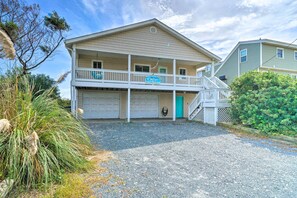 A two-story building with a balcony, a garage, and a staircase leading to the upper level.