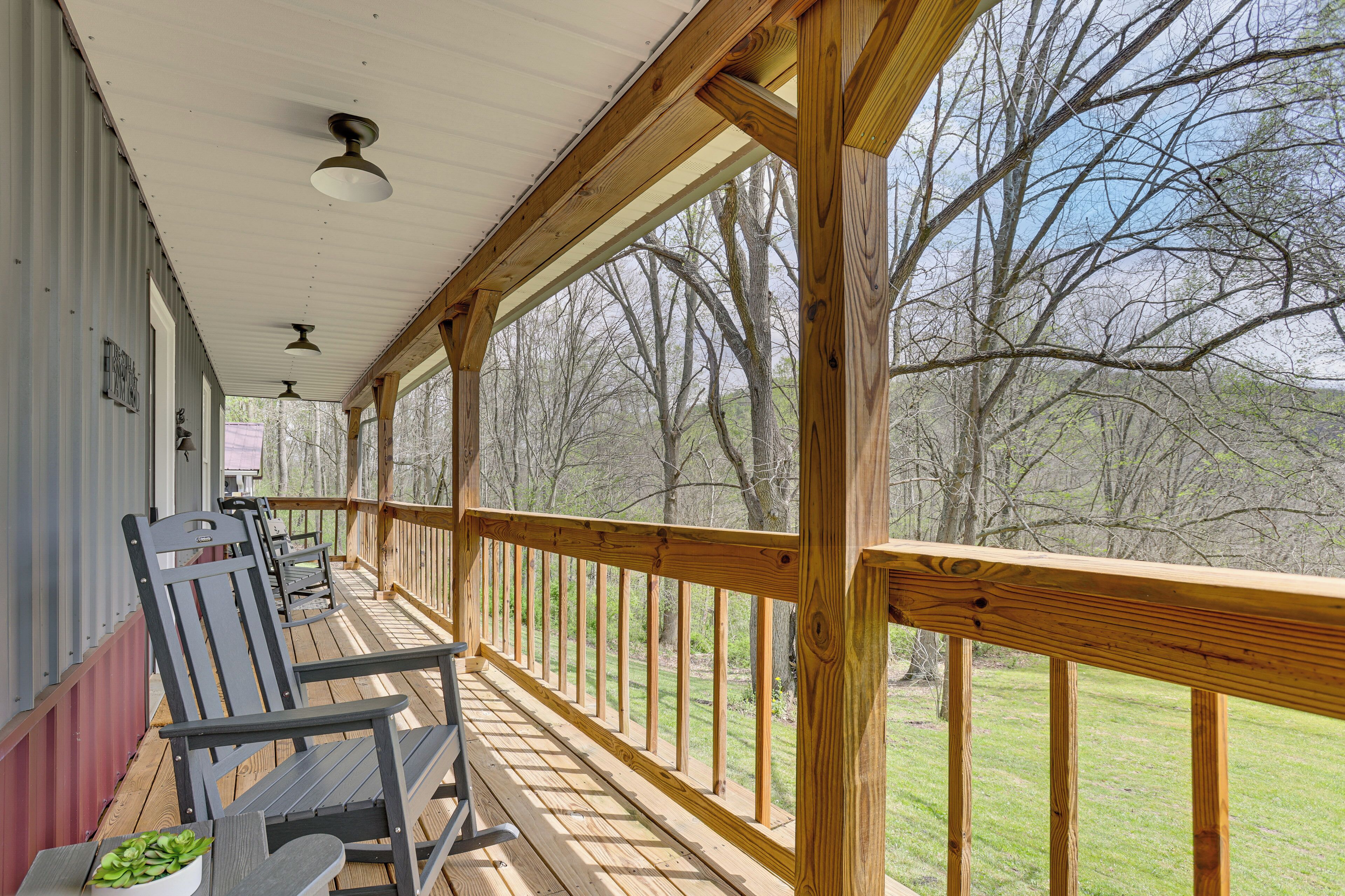 A covered porch with wooden railings, a bench, and a potted plant.