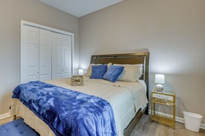 A bedroom with a bed, bedside table, lamp, and a white trash bin. - Peaceful Spartanburg Home Base, 6 Mi to Dtwn! (Spartanburg)