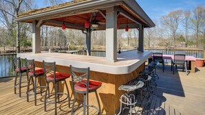 A wooden deck with a bar area, bar stools, and a covered seating area. - 2 Private Pools! Stunning Southaven Group Getaway (Southaven)