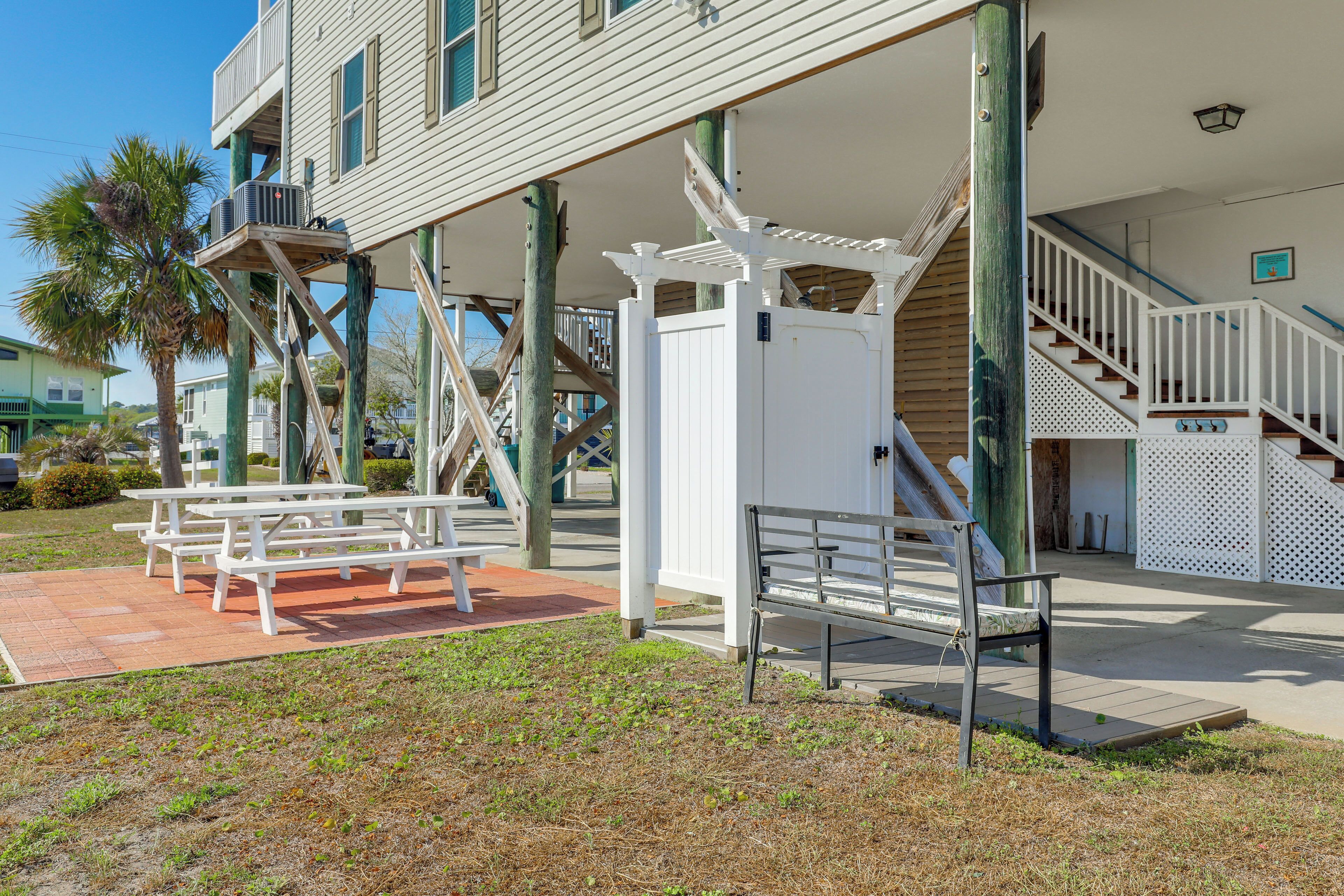 A building with outdoor seating, a staircase, and a covered area.