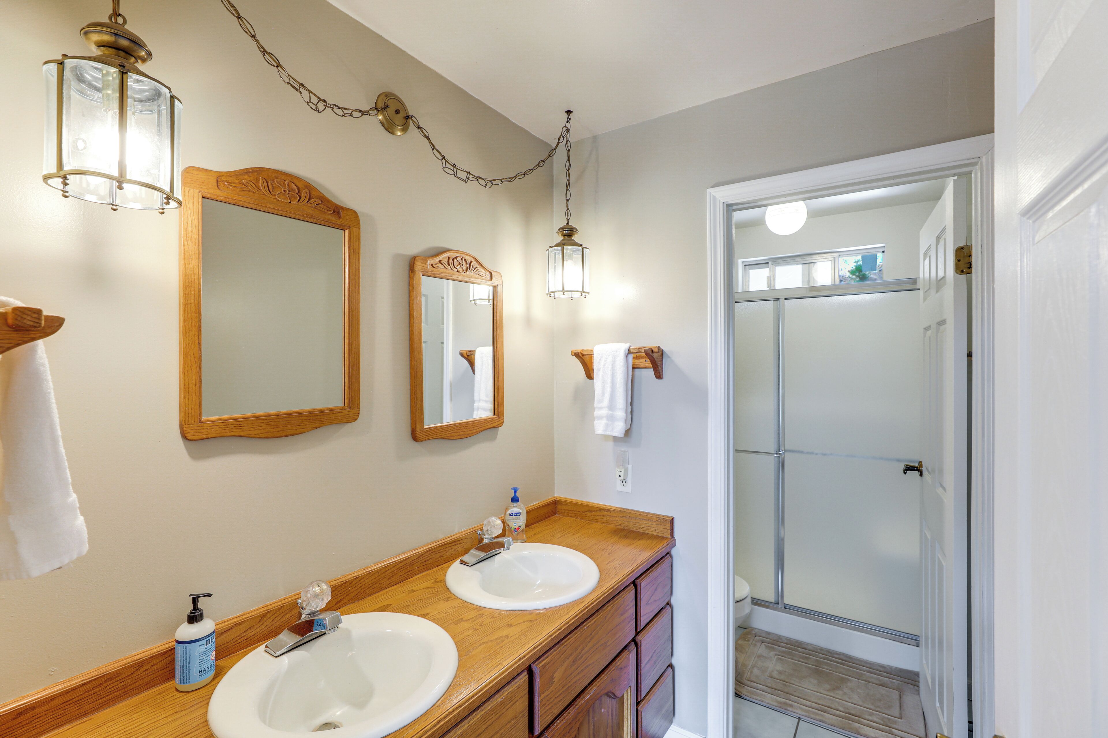Une salle de bain avec deux lavabos, un miroir et une douche.
