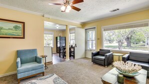 A living room with a ceiling fan, a dining area, and a view of the outdoors. - Port Arthur Homebase: Work, Dine & Play! (Port Arthur)